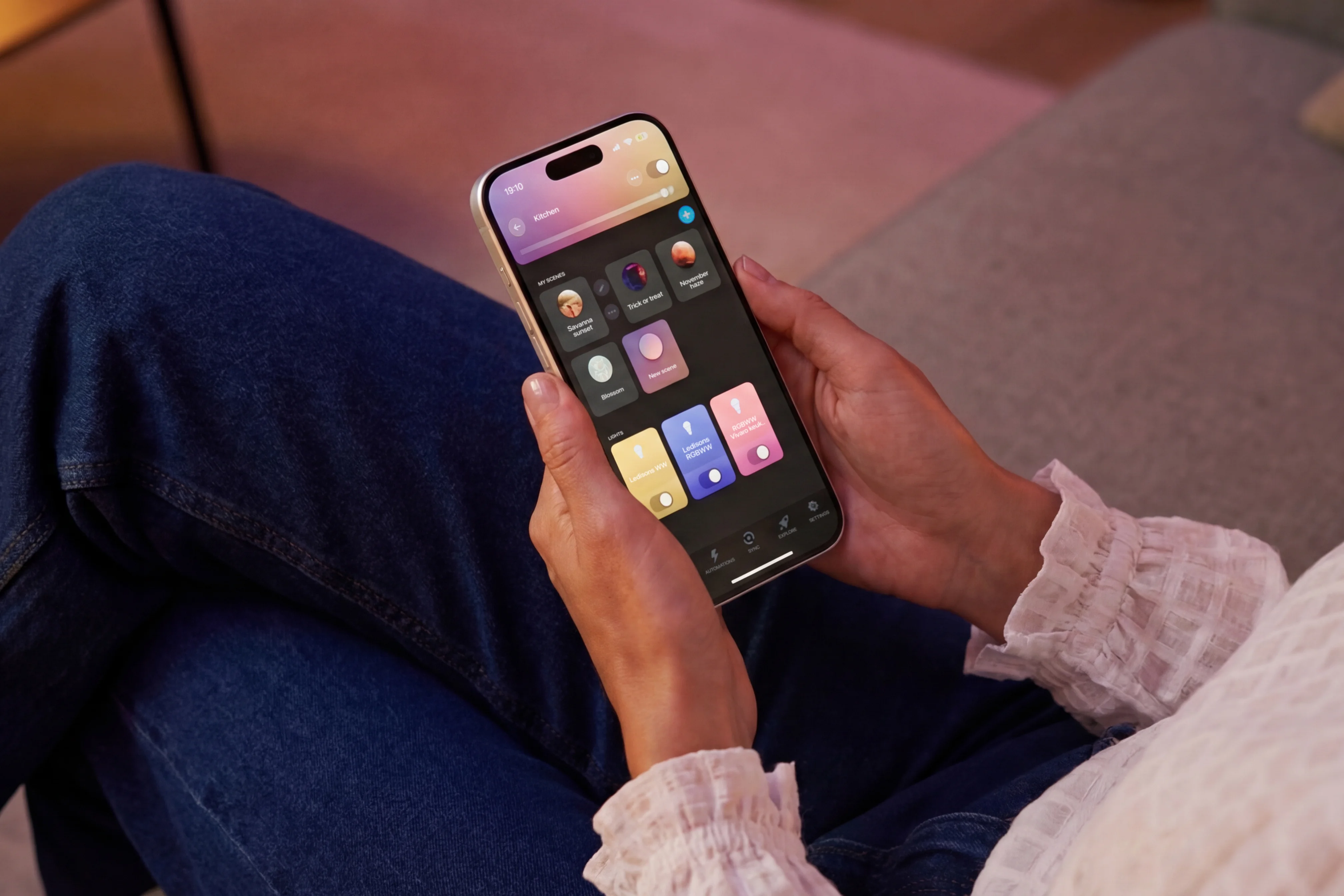 Persoon bedient slimme LED-verlichting met een app op smartphone in de woonkamer